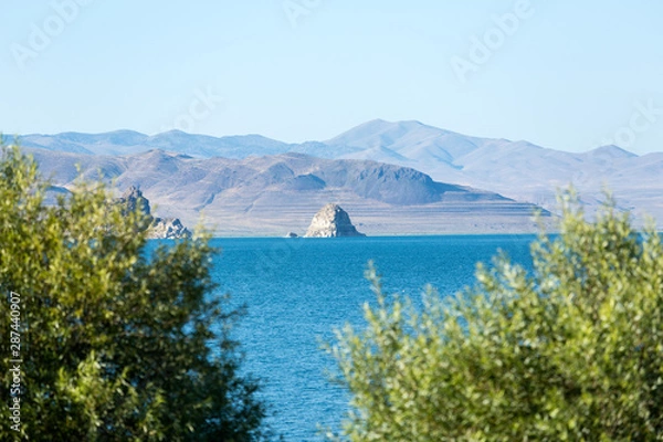Fototapeta The island at Pyramid Lake with expanse of water and framing bushes