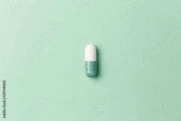 Fototapeta Pharmaceutical medicine pills, tablets and capsules on mint background. Top view. Flat lay. Copy space. Medicine concepts. Minimalistic abstract concept. Neo mint color