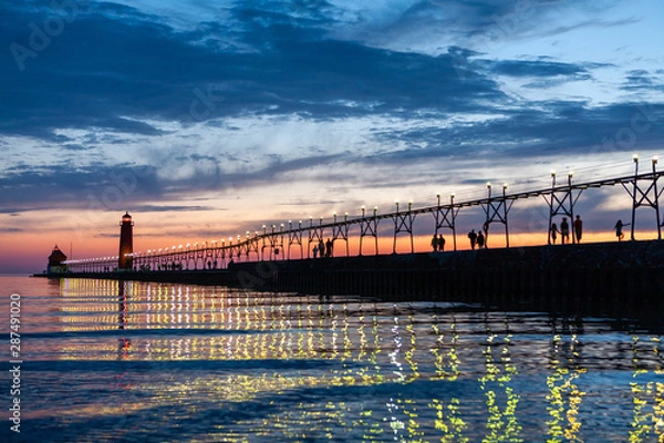 Obraz Grand Haven Lighthouse at sunset with catwalk lights reflected in Lake Michigan