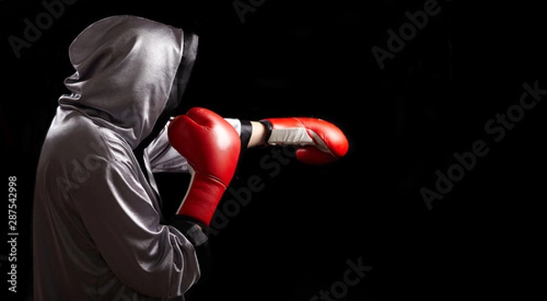 Fototapeta Boxer with red boxing glove is doing shadow boxing.