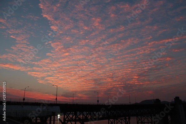 Fototapeta vibrant clouds during golden hour by a bridge near the Golden Gate in San Francisco CA