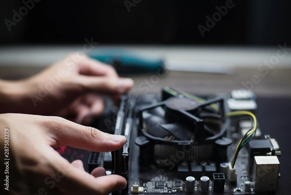 Obraz Computer repair and maintenance, Technician is fixing computer at night, Close-up