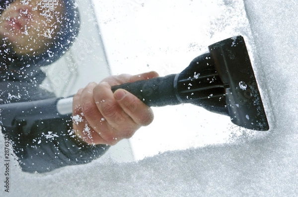 Obraz scraping snow and ice from the car windscreen