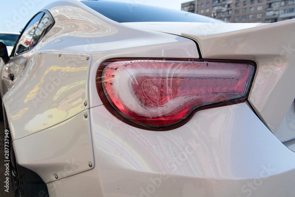 Fototapeta White sports car closeup. Problems with rear lights. Fogged up backlight. Condensation in taillights. Repairs needed.