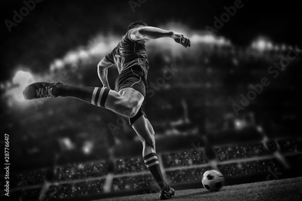 Fototapeta Football player with ball on field of stadium
