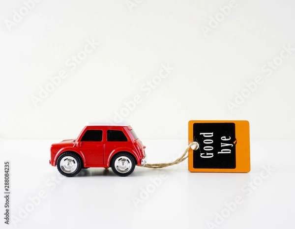 Obraz A red car carry a chalkboard written GOOD BYE over white background
