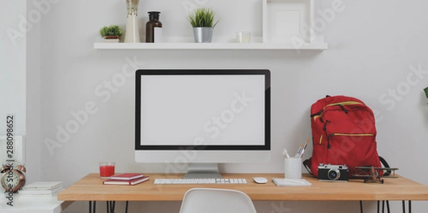 Fototapeta Modern workplace with desktop computer and office supplies with red backpack