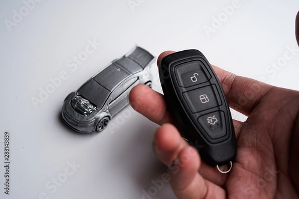 Fototapeta Car loan, Insurance, buy and sell and Auto Finance conceptual image with Car Key remote, die cast car and dollar bills 