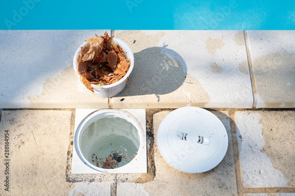 Fototapeta Removing a pool skimmer basket to empty the leaves out