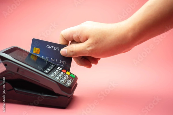 Fototapeta Man Hands swiping Credit card on Credit card machine or Credit card Terminal, Finance concept.