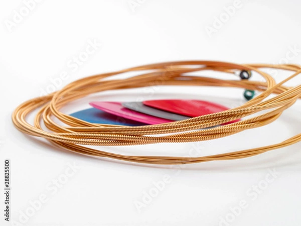 Fototapeta Acoustic guitar strings and plectrums on white background