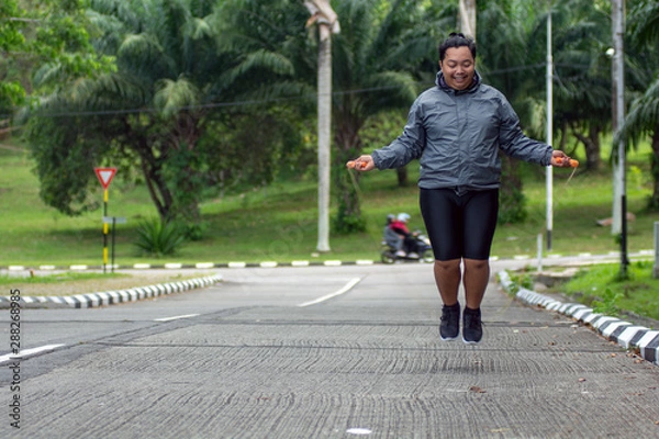 Obraz fat obese man doing exercises with jumping rope overweight guy training workout weight loss