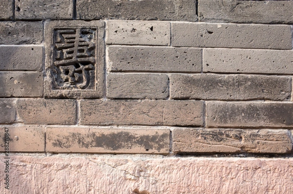 Obraz The old brick wall engraved with Chinese characters