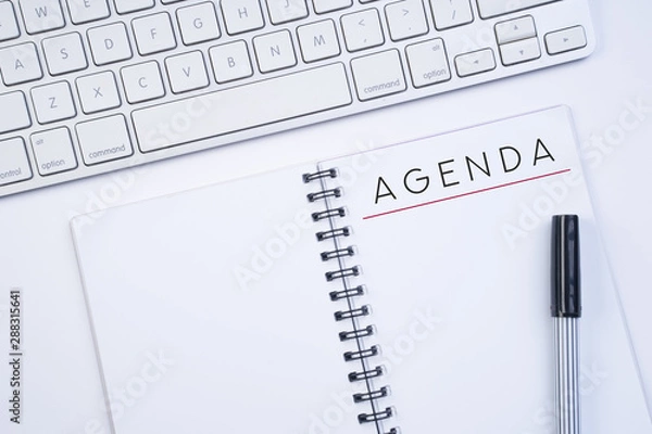 Fototapeta Business agenda, planning concept. Spiral notebook with Agenda text on white background. Flat lay or top view.