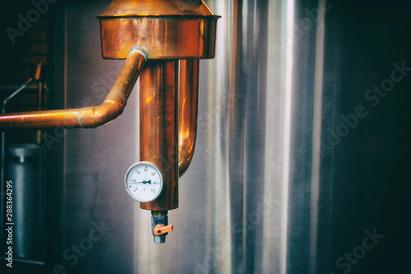 Fototapeta Steam gauge. Industrial equipment for brandy production. .Copper still alembic inside distiller to distill grapes and produce spirits. Noises and large grain - stylization under the film. Soft focus