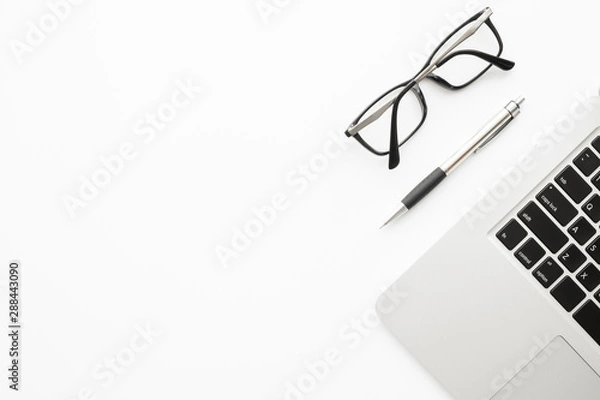 Fototapeta White office desk table with laptop computer, pen and eye glasses. Top view with copy space, flat lay.
