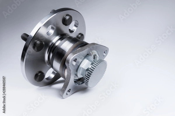 Obraz New Wheel hub assembly with bearing. This is part of the car suspension on a gray background with a gradient. The concept of new car parts
