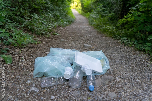 Obraz girl collecting plastic in the field, with her mother and grandmother. collect plastic bottles