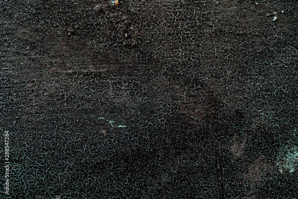 Fototapeta Metal texture covered black paint. Net of green cracks. Rough surface. Black background for text and design