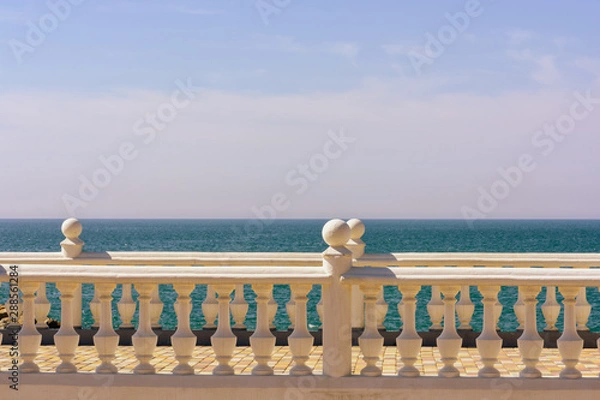 Fototapeta White stone balustrade overlooking the blue sea