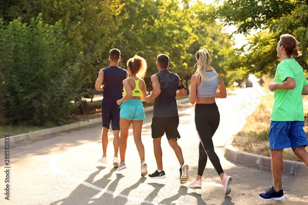 Fototapeta Group of sporty young people running outdoors