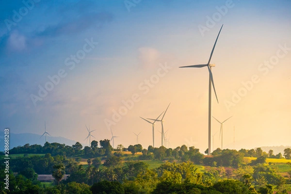 Fototapeta Green energy concept, eco power. Wind turbine located along the hill with the wind blowing all the time. Can produce renewable energy as well. Considered a clean energy.