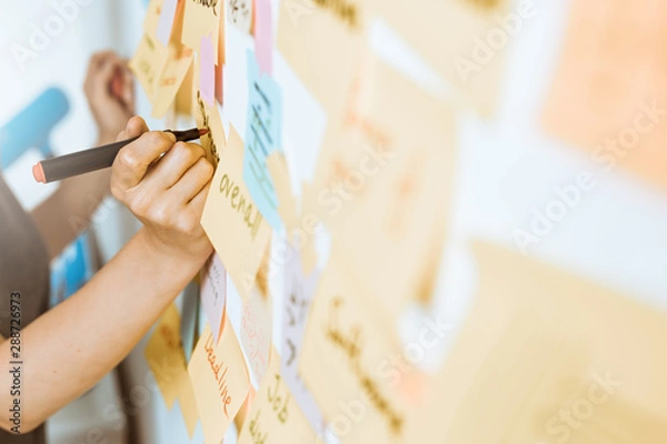 Fototapeta Business people write down an important note, using on the paper stickers post. Brainstorming, teamwork. 