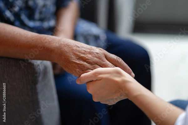 Obraz Hand of elderly woman holding hand younger woman, Helping hands, take care for the elderly concept.