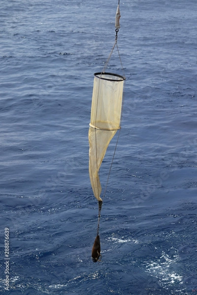 Fototapeta Plankton net on the blue water background. Science equipment for sampling of water organisms deployment.