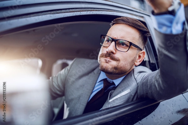 Fototapeta A sharp dressed man finding himself caught in a rush hour and slowly succumbing to road rage.