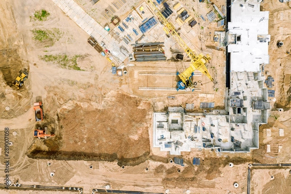 Fototapeta heavy building machinery working at construction site. top down aerial view