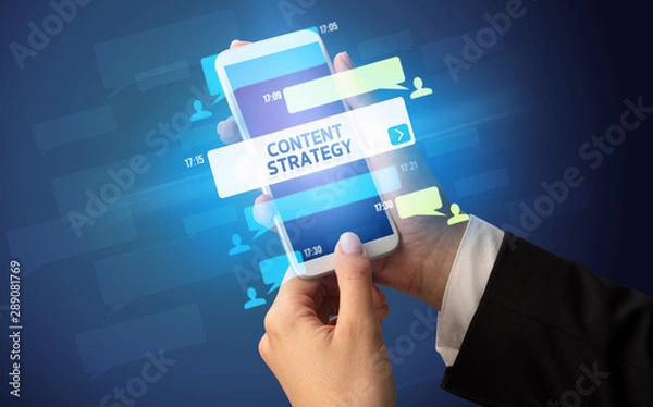 Fototapeta Female hand typing on smartphone with CONTENT STRATEGY inscription, social networking concept