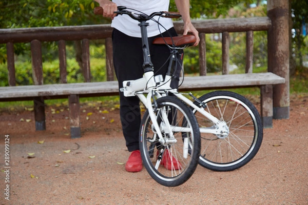Fototapeta 折り畳み自転車を折りたたむ男性