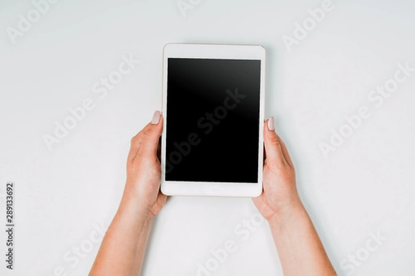 Fototapeta Modern workspace with woman hands and tablet pc copy space on white color background. Top view. Flat lay style. Minimalism