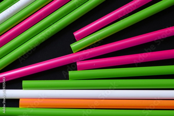 Fototapeta Plastic straws different colors on a dark background close up
