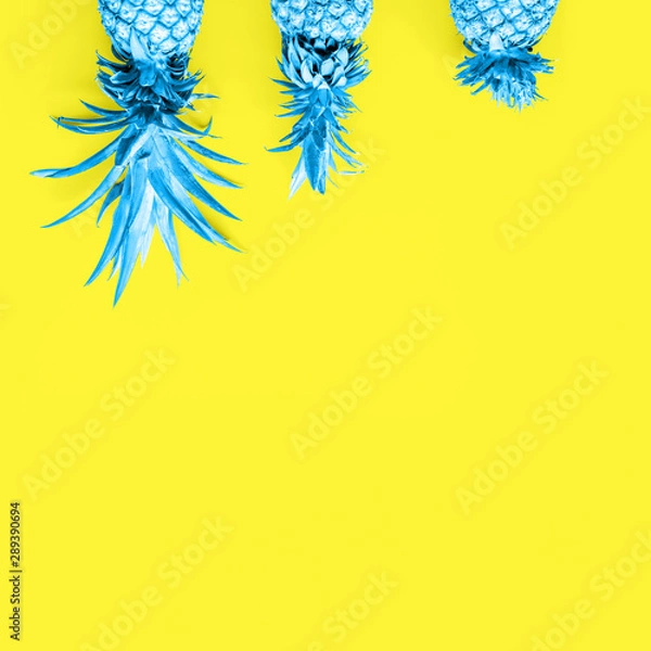 Fototapeta Creatively toned pineapples at the yellow solid drop with place for text. Trendy modern duotone background. Square
