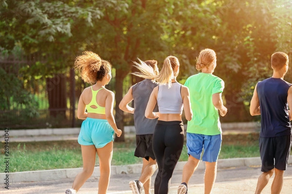 Fototapeta Group of sporty young people running outdoors