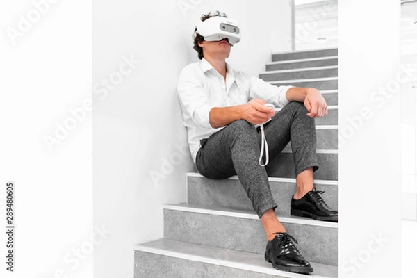 Obraz Man wearing virtual reality goggles in modern bright co-working office. the VR experience.