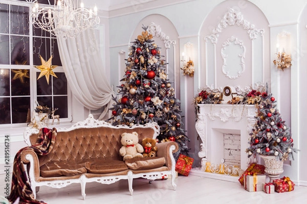 Obraz Tall Christmas tree decorated with red ornaments, baroque sofa, stucco wall in spacious light room in baroque style.