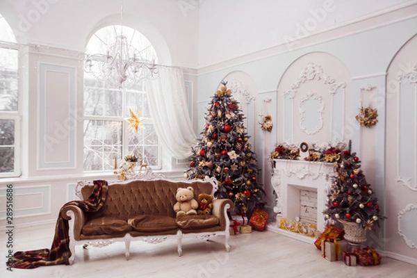 Obraz Tall Christmas tree decorated with red ornaments, baroque sofa, stucco wall in spacious light room in baroque style.
