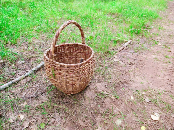 Fototapeta wiklinowy kosz przy piaszczystej drodze