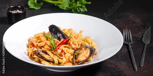 Obraz Homemade pasta with mussels, sprinkle with chopped parsley and basil. Delicious of pasta with mussel