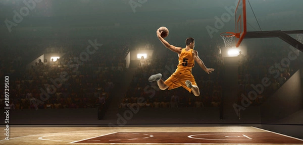 Fototapeta Koszykarz na boisku do koszykówki w akcji. Slam dunk. Strzał z wyskoku