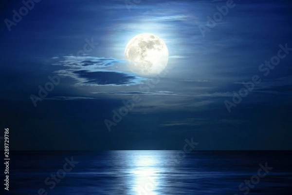 Fototapeta Super full moon and cloud in the blue sky above the ocean horizon at midnight, moonlight reflect the water surface and wave, Beautiful nature landscape view at night scene of the sea for background
