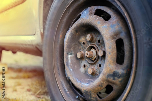 Fototapeta replacing a wheel in a car, loosening nuts with a hand wrench.