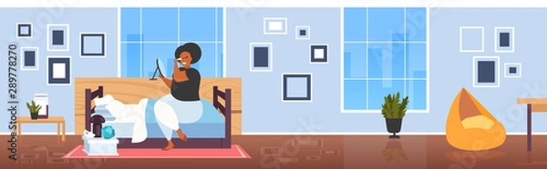 Fototapeta fat obese woman applying black mascara african american girl looking at mirror touching eyelashes using tassel making professional make up modern bedroom interior flat full length horizontal