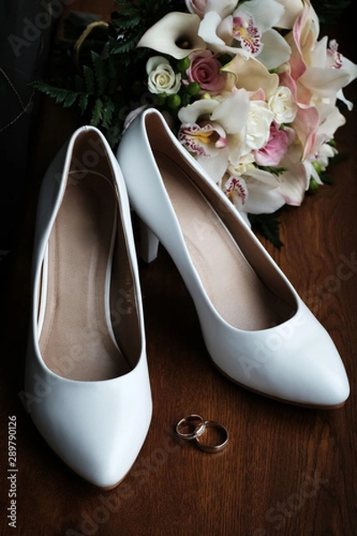 Fototapeta Wedding still life of flowers rings and shoes bride.