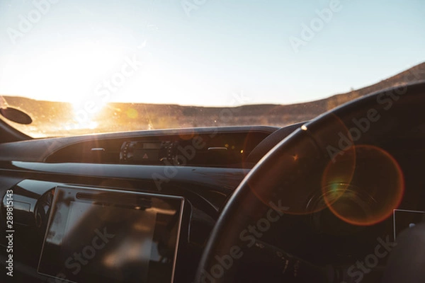 Fototapeta dash of car looking out at sunset 