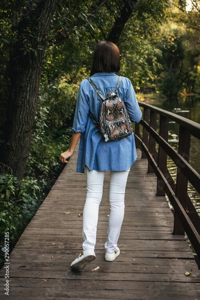 Obraz Young stylish woman with snakeskin python backpack.