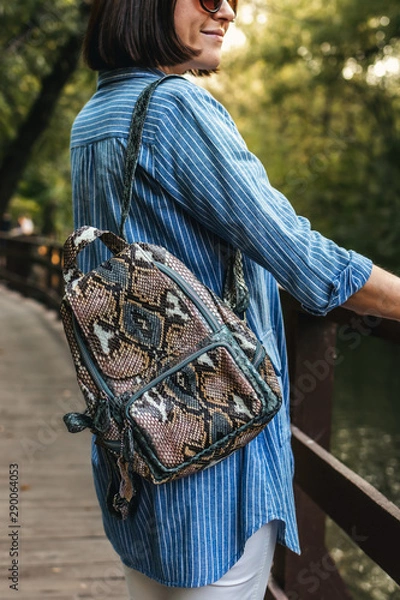 Obraz Young stylish woman with snakeskin python backpack.